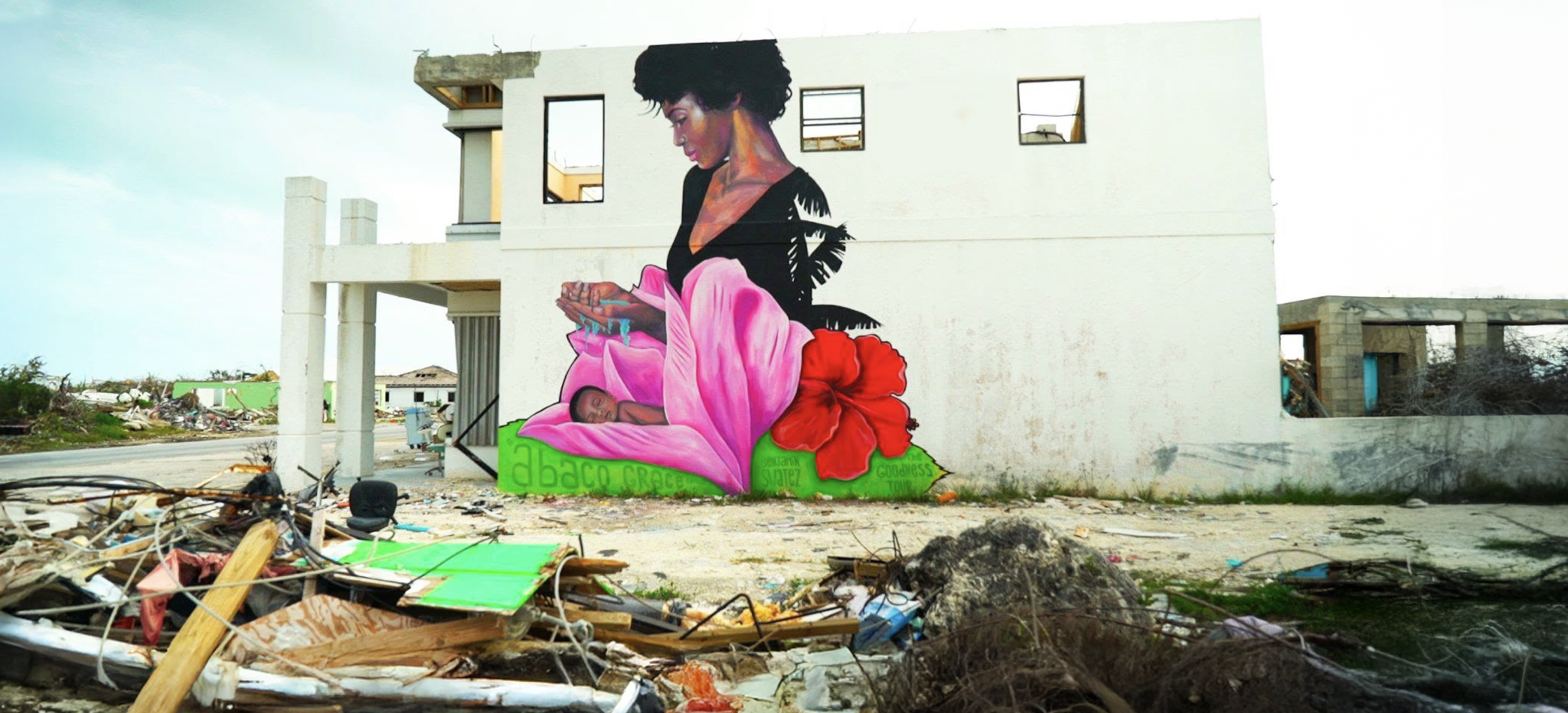 Mural of a woman and child painted on a storm-damaged building in Abaco